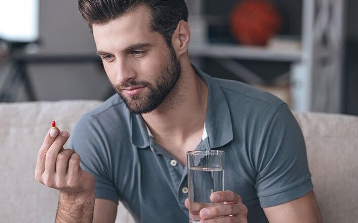 a man is drinking a pill to enlarge the head of his penis